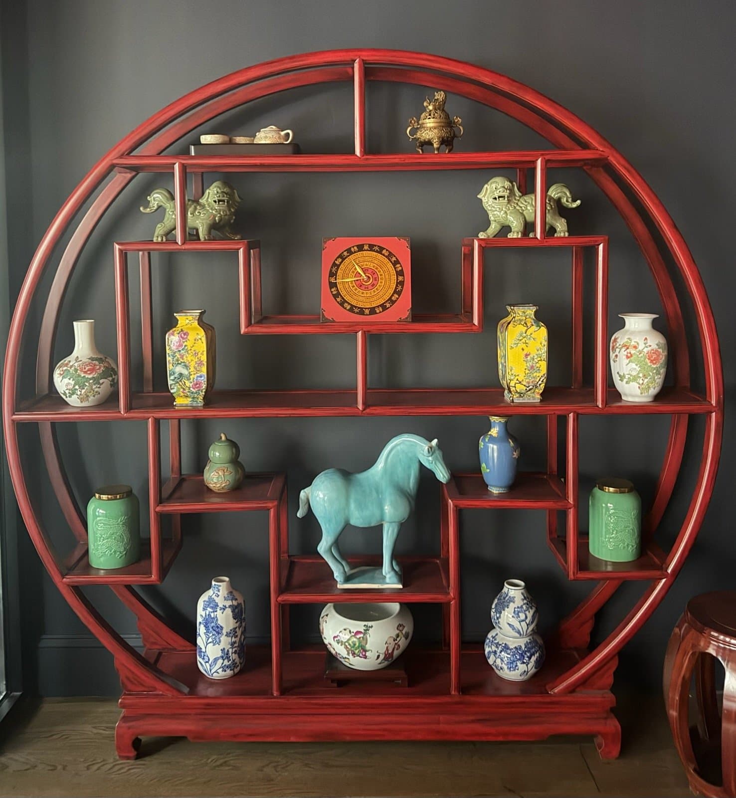 Traditional Chinese display shelf with porcelain and red lacquer interior detail