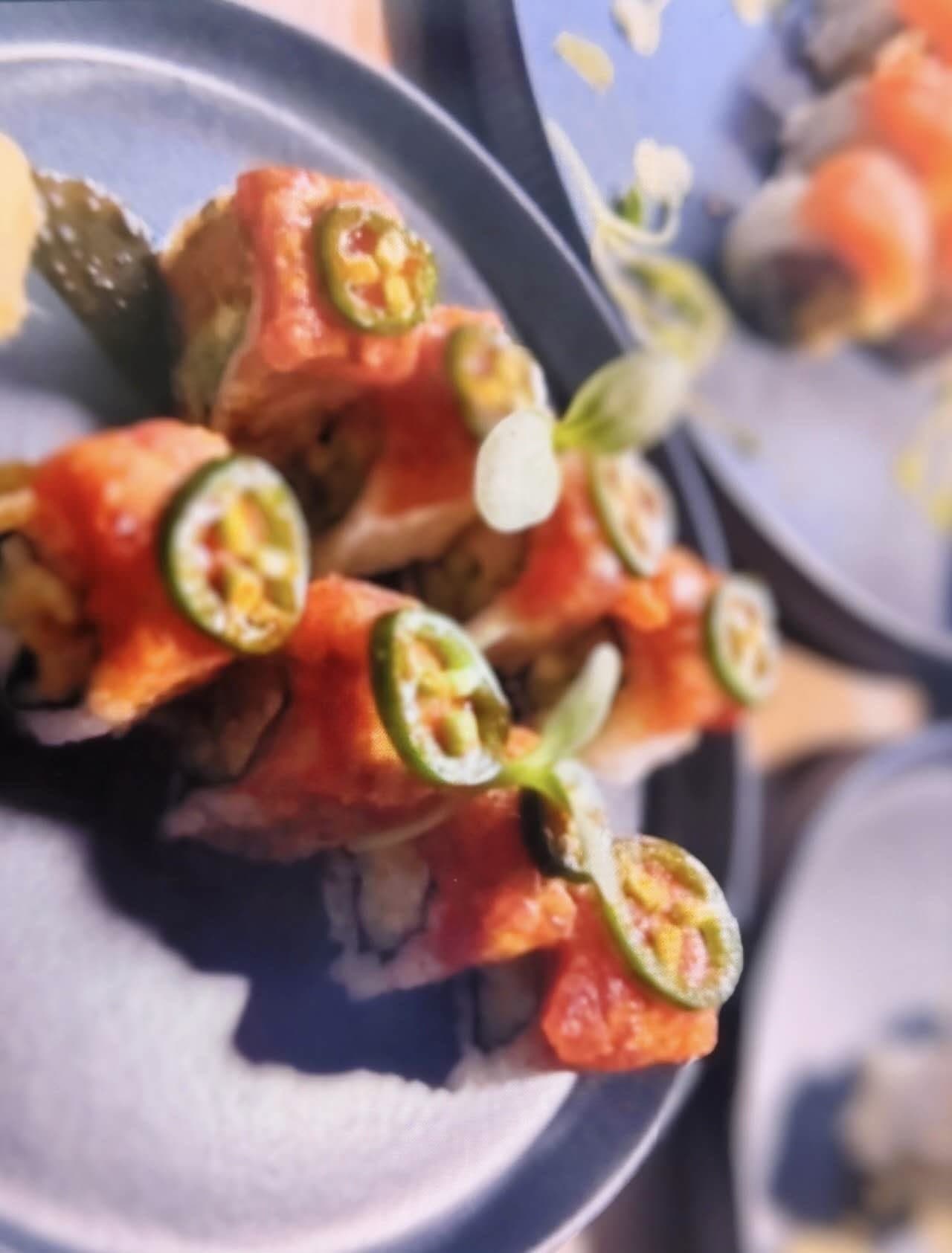 Handcrafted sushi rolls with jalapeño and microgreen garnish